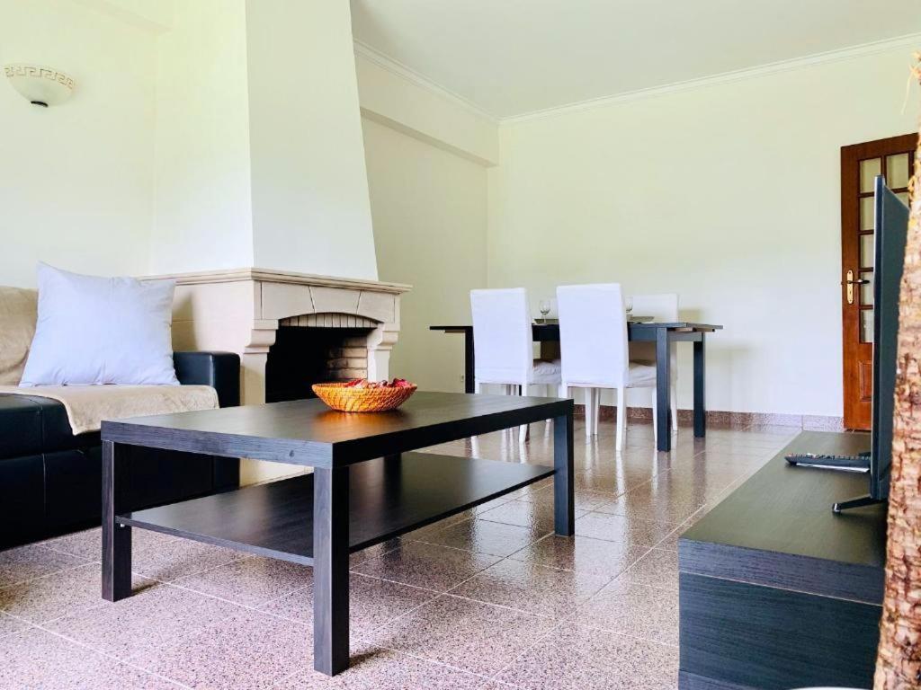 sala de estar con mesa, sillas y chimenea en Sónia&Irene Apartments en Setúbal