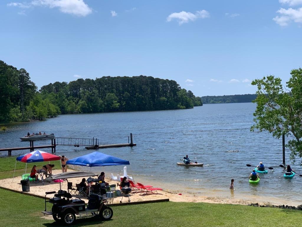 um grupo de pessoas na praia em um lago em Alpine Lakeview Motel Room WiFi,Sandy beach Boat Ramp,Pier,Marina,Bath House with Laundromat em Hemphill