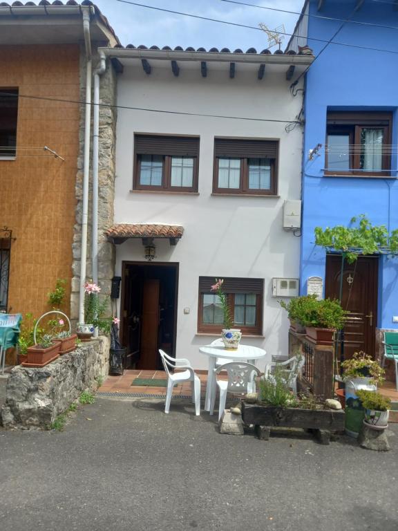 a house with a table and chairs in front of it at La Casina de Póo de LLanes in Po
