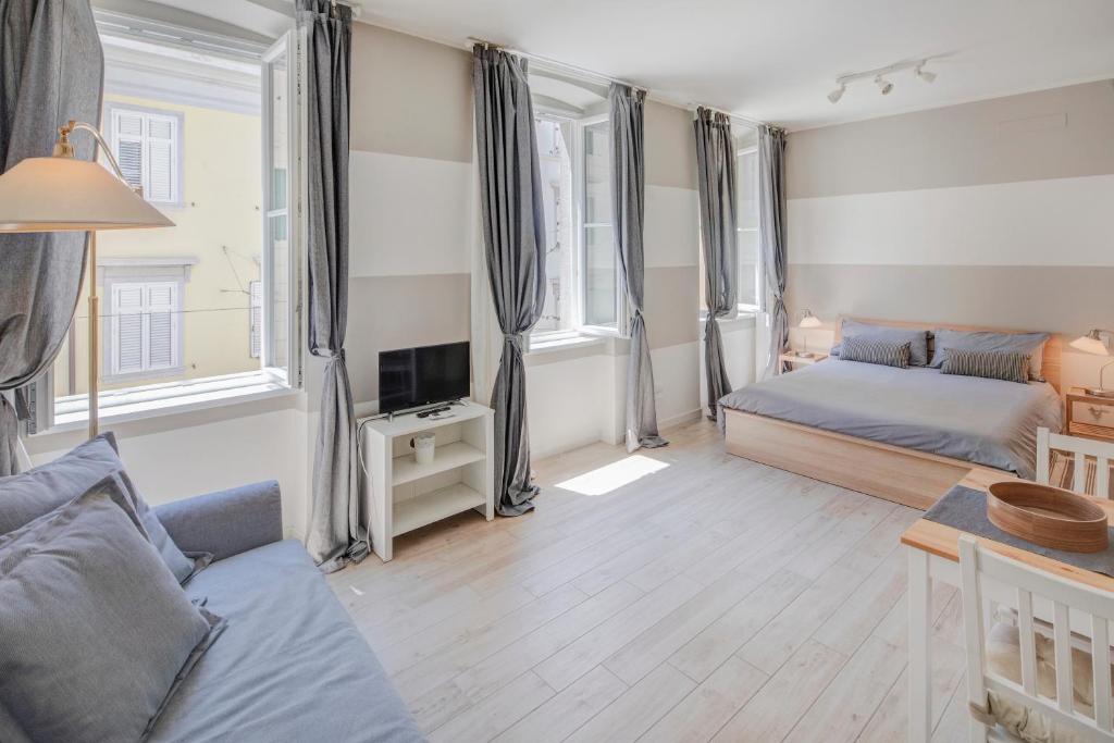 uma sala de estar com duas camas e um sofá em Quattrorighe em Trieste