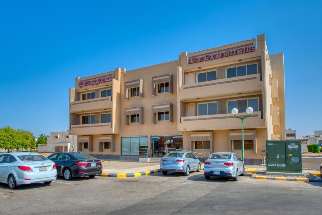 un bâtiment avec des voitures garées dans un parking dans l'établissement Al Fanar Al Alami 2- Haya'a malakeya, à Yanbu