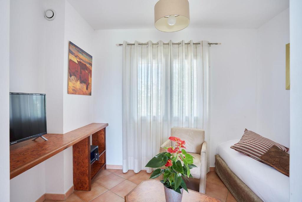 TV a/nebo společenská místnost v ubytování Logis Hôtel Le Rodin
