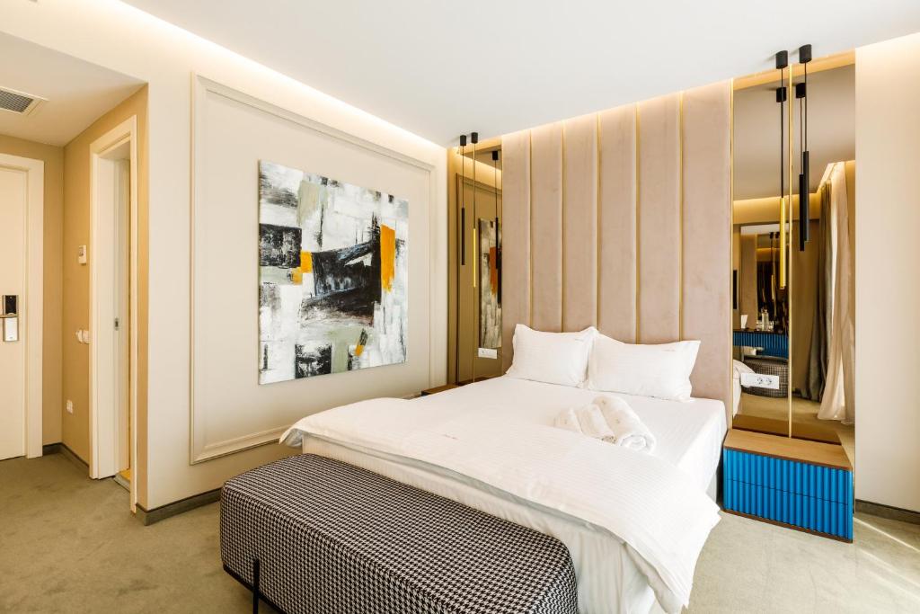 ein Schlafzimmer mit einem großen Bett mit weißer Bettwäsche in der Unterkunft Onal Boutique Hotelier in Mamaia