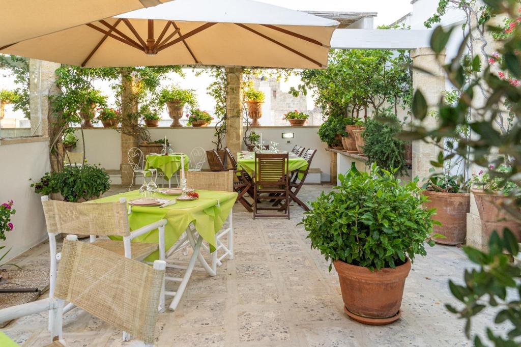 a patio with a table and chairs and an umbrella at Anticadimora Dei Pepe in Salve