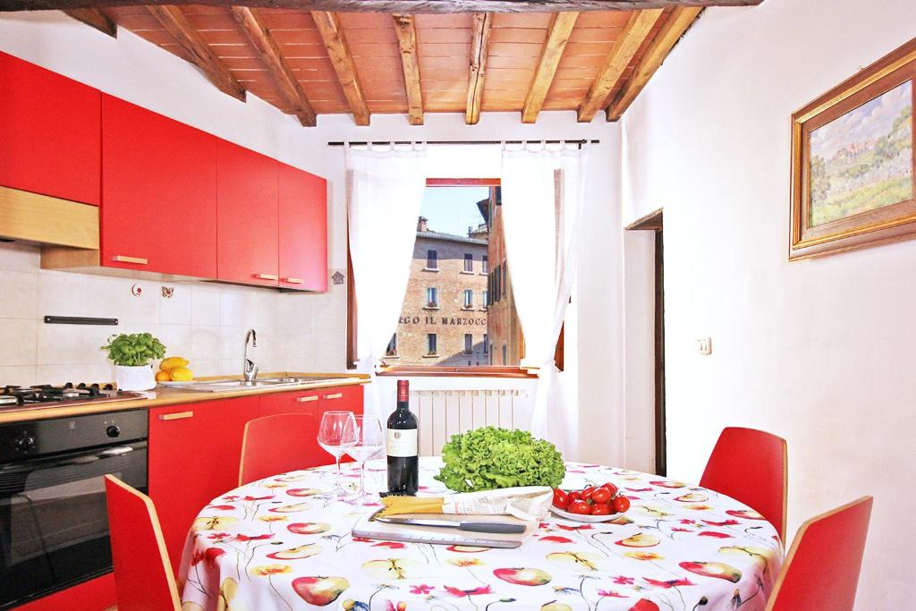 cocina con mesa y botella de vino en Girolamo Apartment - Super Central, Private Parking & Outdoor Area, en Montepulciano