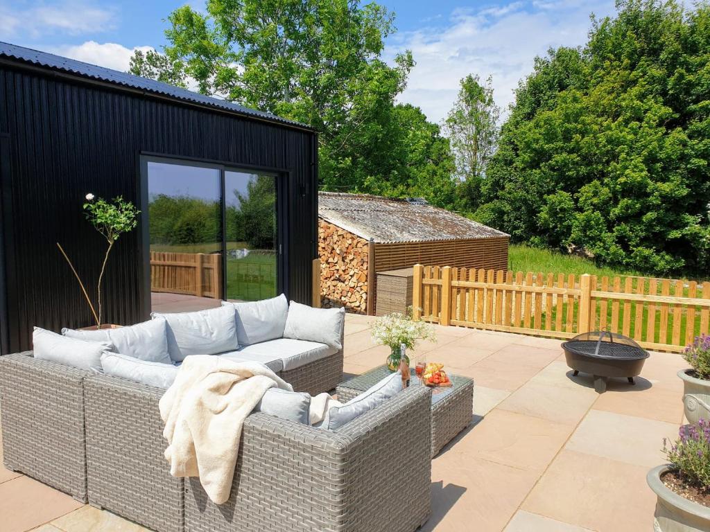 a patio with a couch and a fire hydrant at Finest Retreats - Blackbarn Wood in Balsham