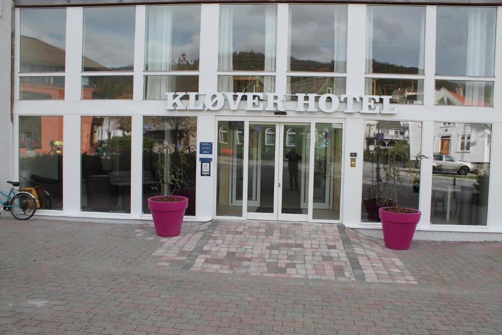 a building with two potted plants in front of it at Kløver Hotel in Sauda