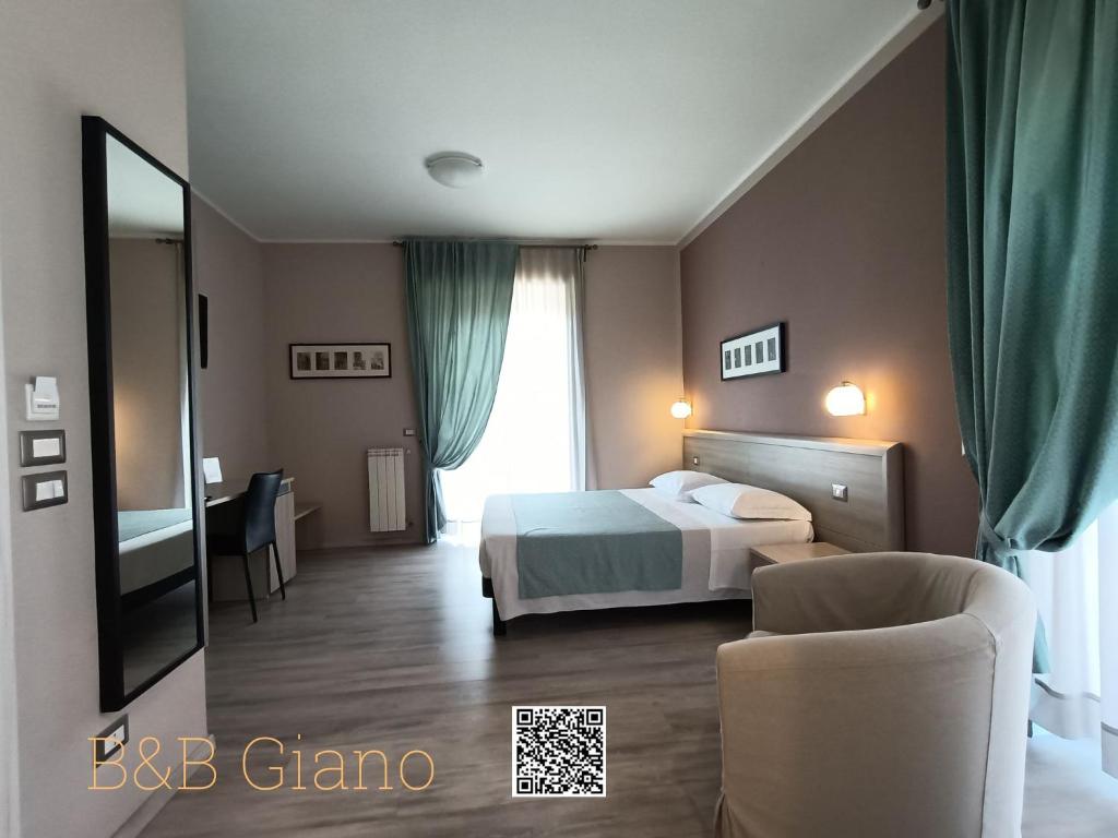 a hotel room with a bed and a chair at B&B Giano in Formia