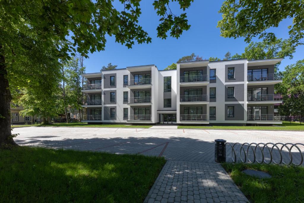 an apartment building in front of a park at Oasis Apartments in Jūrmala