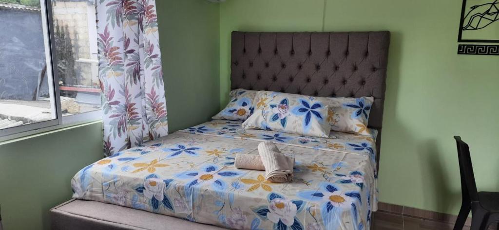 a bedroom with a bed with a floral bedspread at Apartaestudio Perdomo Shantiers en San Andres Islas in San Andrés