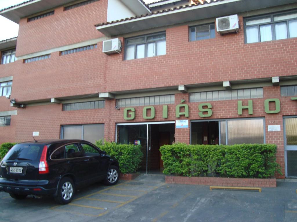 une voiture garée dans un parking en face d'un bâtiment dans l'établissement Goias Hotel, à Goiânia