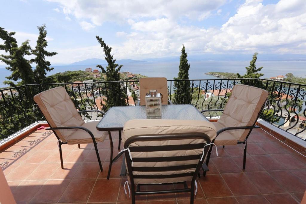 a patio with a table and chairs on a balcony at Sofia's pottery house in Volos