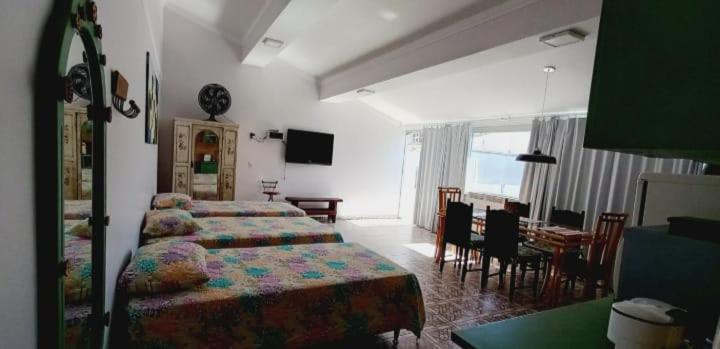 a bedroom with two beds and a dining room with a table at Pousada Minha Casa in São Lourenço