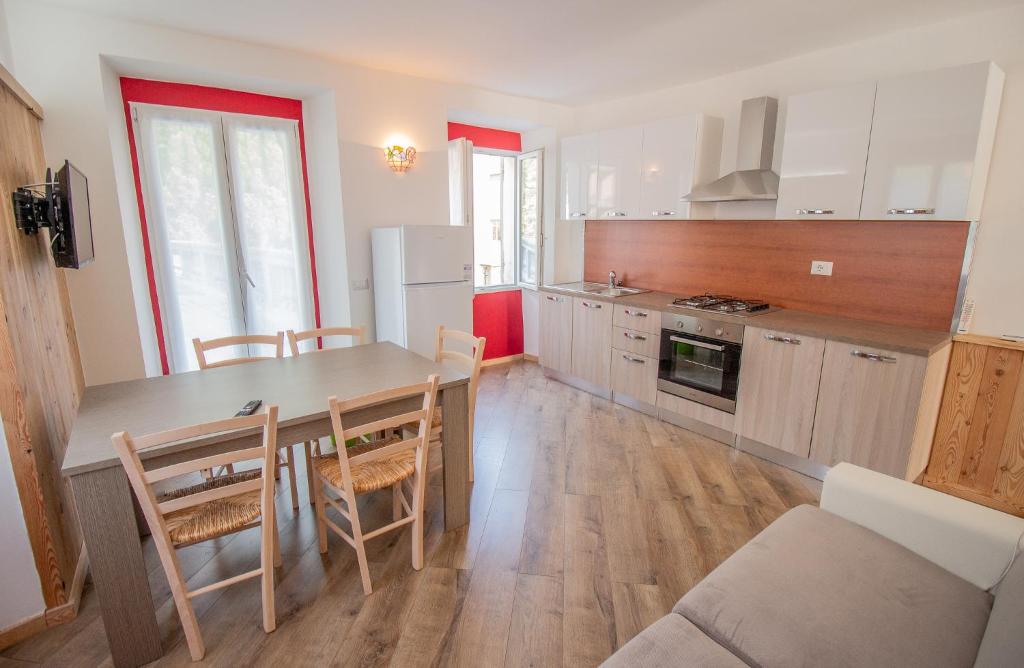 - une cuisine avec une table et des chaises dans la chambre dans l'établissement Il tulipano della Valle Soana, à Ronco Canavese