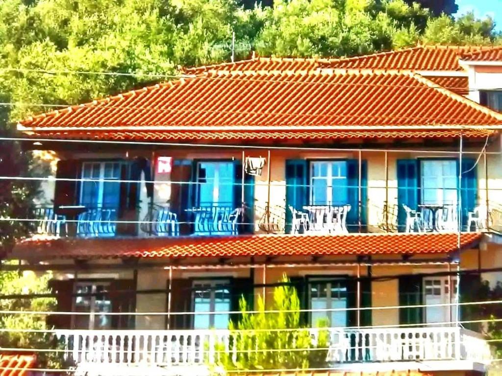 Casa con techo naranja y balcón en Peyko Rooms, en Kerion