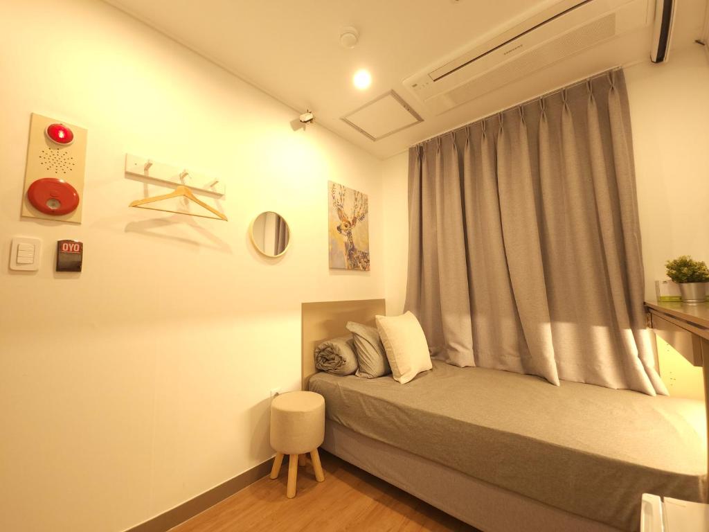 um quarto com uma cama com uma janela e uma cadeira em OYO Hostel Myeongdong 2 em Seul