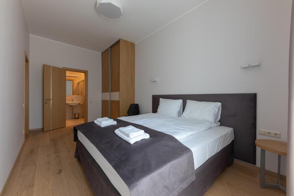 a bedroom with a large bed with two towels on it at Oasis Apartments in Jūrmala