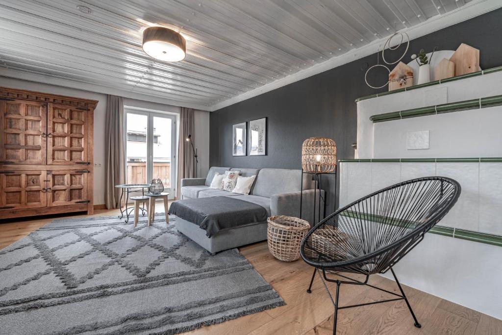 a living room with a couch and a chair at Bewegte Berge Apartments in Saalfelden am Steinernen Meer