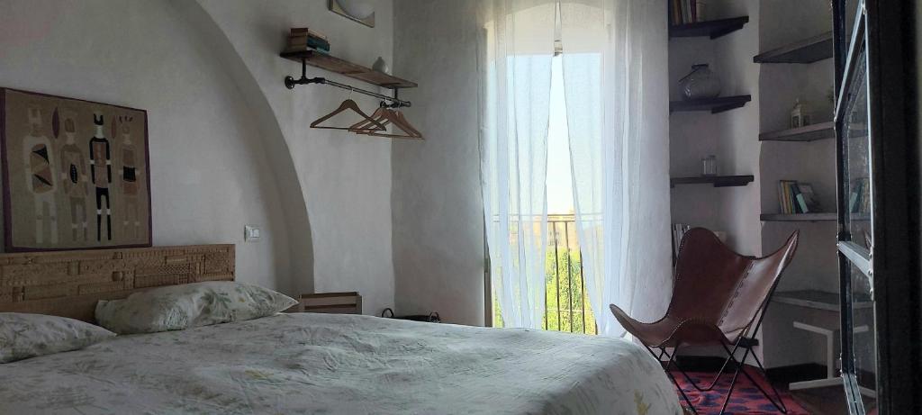 una camera con un letto e una sedia e una finestra di La Tana di Margherita a Perugia