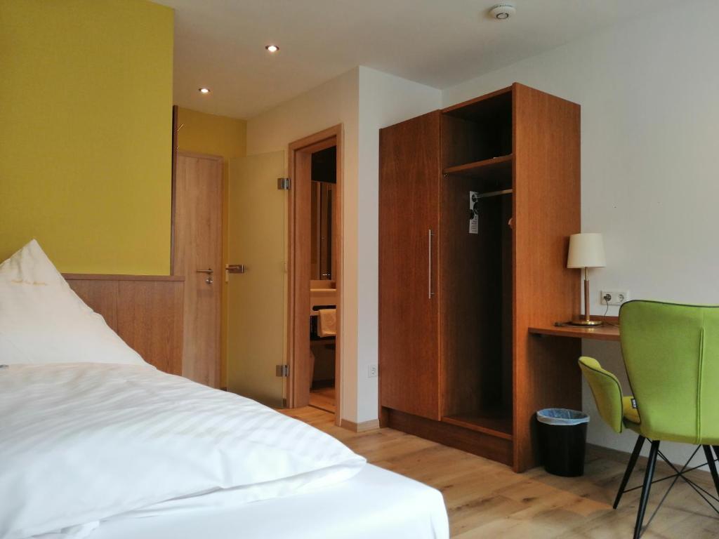 Schlafzimmer mit einem Bett, einem Schreibtisch und einem Stuhl in der Unterkunft Land-gut Hotel zur Brücke garni in Drolshagen