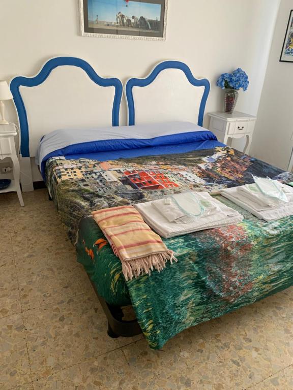 a bedroom with a bed with a blue headboard at dreamingrooms in Riomaggiore