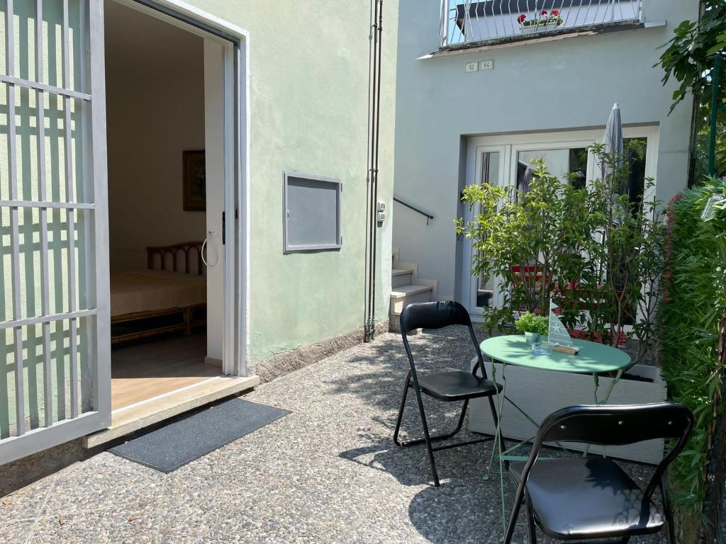 un patio con mesa y sillas junto a un edificio en Vittoria room, en Bardolino