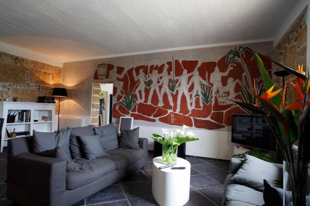 a living room with a couch and a mural at Case Giannone in Santa Flavia