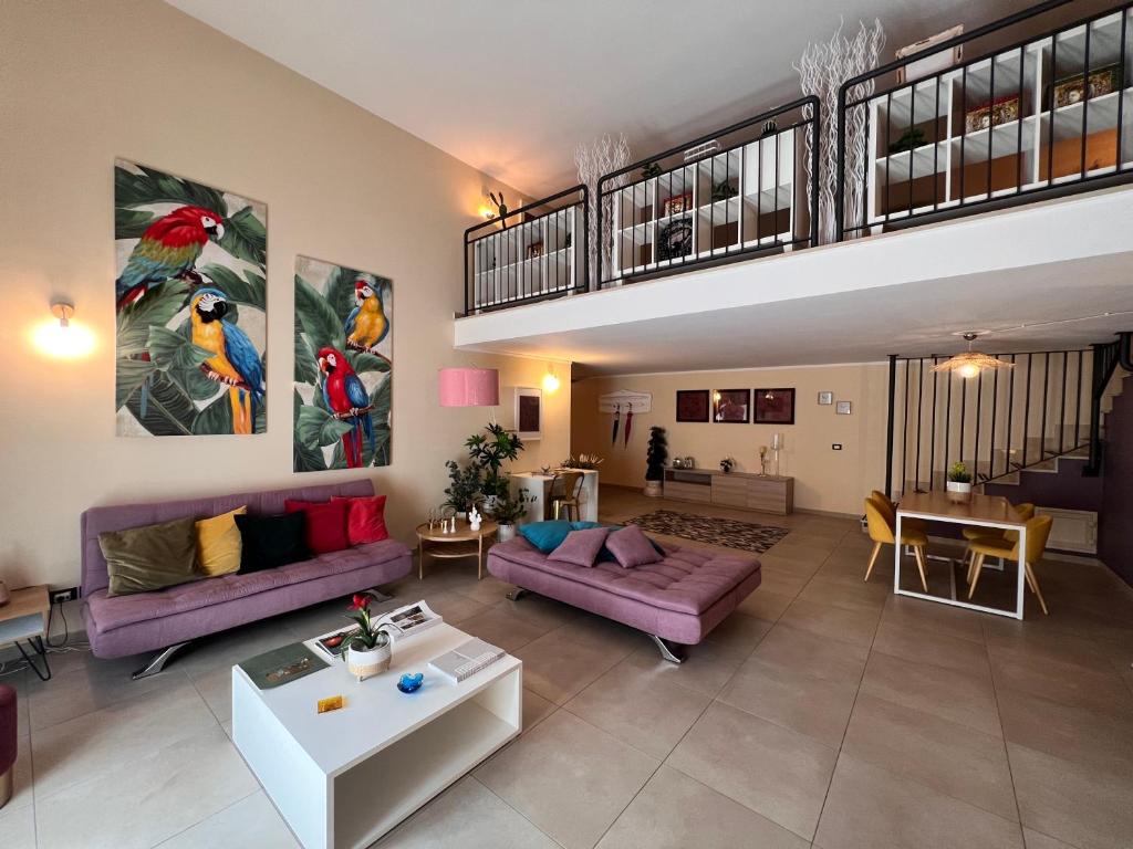 een woonkamer met paarse banken en een trap bij ZEFIA HOME in Catania