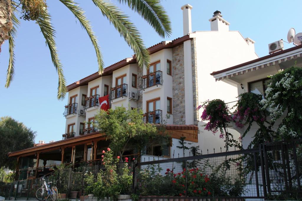 a building with a palm tree in front of it at Konak Tuncel Efe in Datca