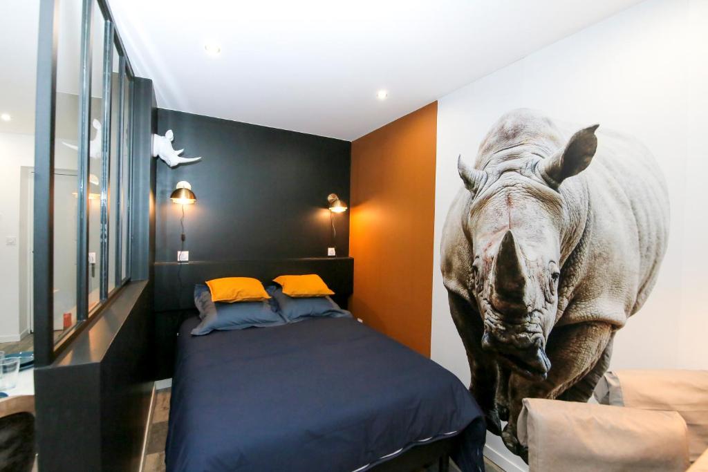 - une chambre avec un lit avec une tête de dinosaure sur le mur dans l'établissement Le Rhinocéros, T1 hypercentre chic et cosy, Wifi par SOVALFI, à Saint-Étienne