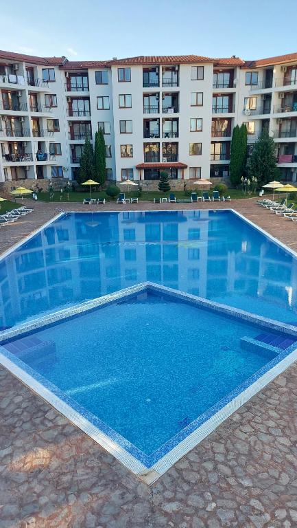 una gran piscina azul frente a un edificio en Апартамент Анастасия Аполон 6, en Ravda
