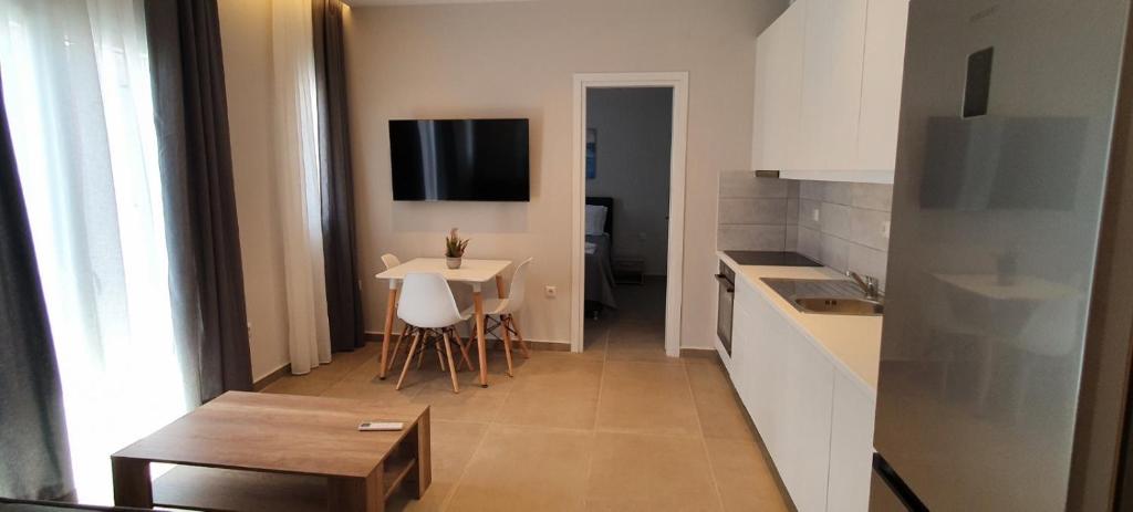 une cuisine avec une table et une petite table ainsi qu'une cuisine avec une table à manger dans l'établissement Astra Studios Karpathos Island, à Karpathos