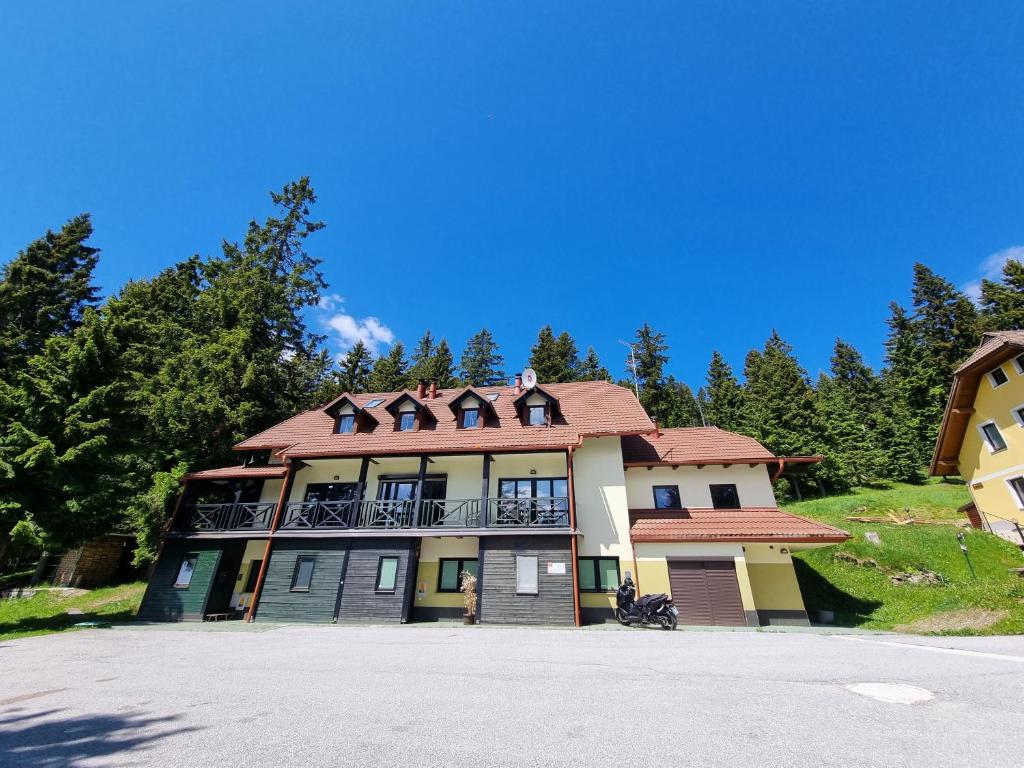 une grande maison avec un toit rouge dans l'établissement Apartma Jakob Rogla, à Vitanje