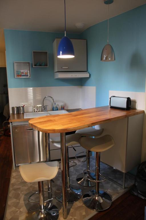 - une cuisine avec une table en bois et des tabourets de bar dans l'établissement Apartment Lourmel, à Paris