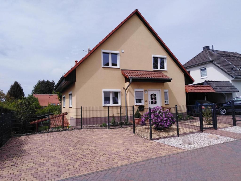 uma casa com uma cerca em frente em Ferienwohnung "Schwalbennest" em Motzen