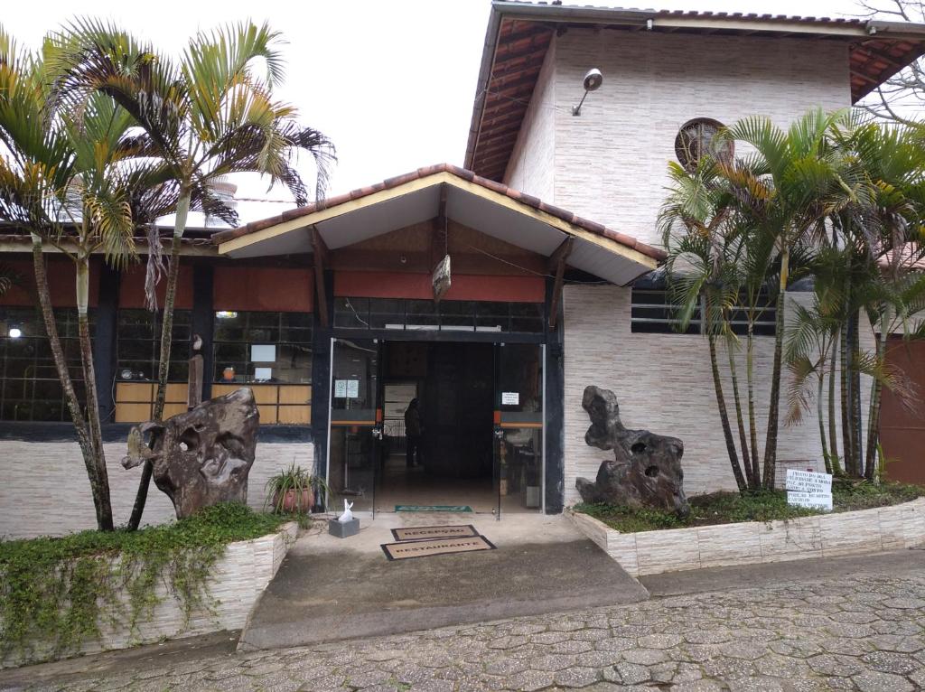 un edificio con palmeras delante en Pousada Juriti - Eco Hotel, en São Roque