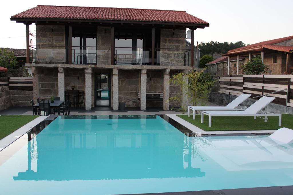 a house with a swimming pool in front of a house at CASA VACACIONAL ACIO in Ourense