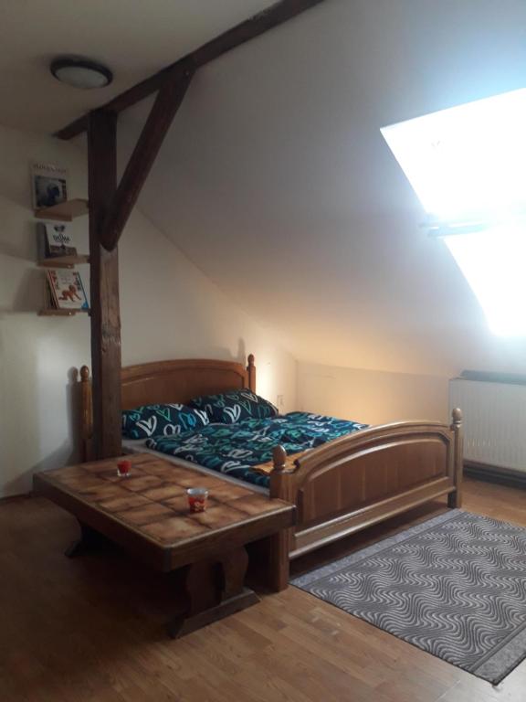 a bedroom with a bed and a table at Podkrovní apartmán in Olomouc