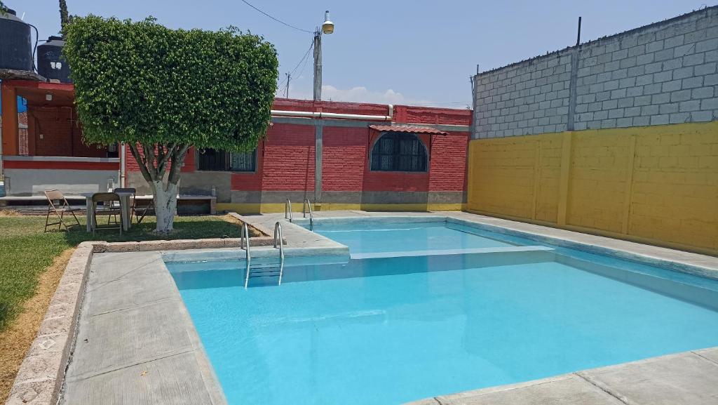 a large blue swimming pool next to a building at Casa De Descanso Cuautla Morelos in Cuautla Morelos
