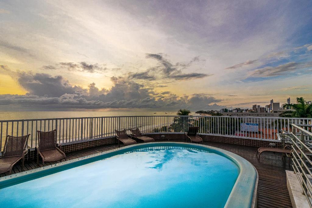 einen Pool auf einem Balkon mit Blick auf das Wasser in der Unterkunft Happy Hotel Manaíra in João Pessoa