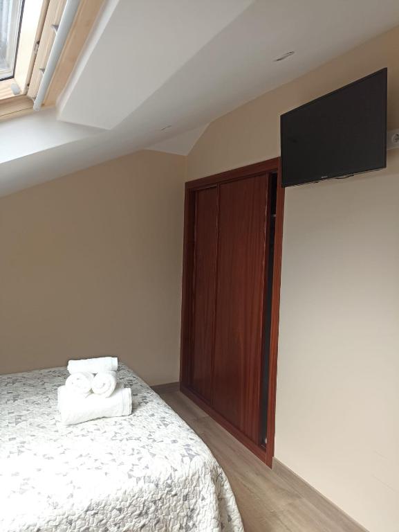 a bedroom with a bed with towels on it at Hotel Restaurante el Fornon in Novellana