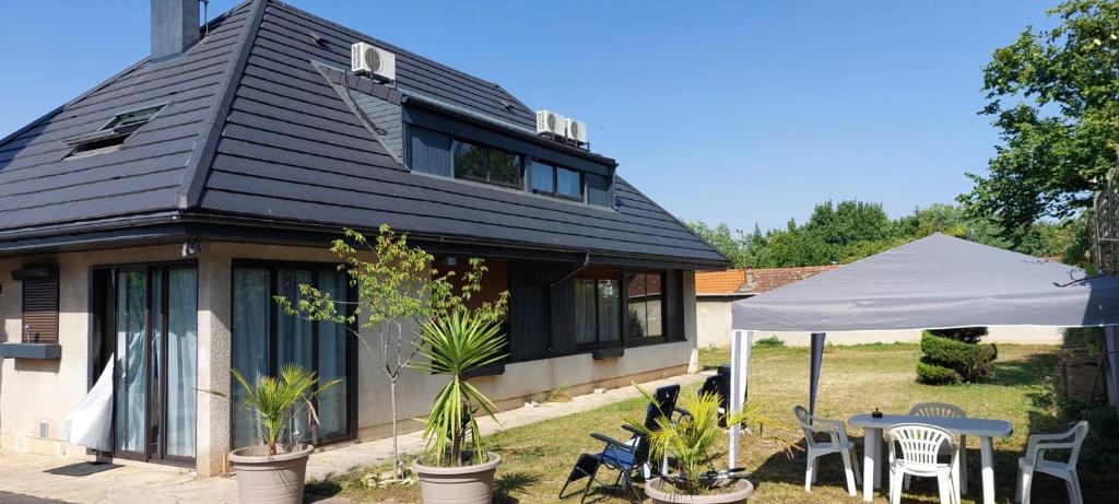 une maison avec une table, des chaises et une tente dans l'établissement L'Escale du Monde, à Vénissieux