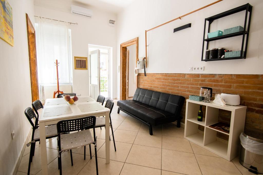 セゲドにあるHarmónia Apartmanのリビングルーム(黒い革張りのソファ、テーブル付)