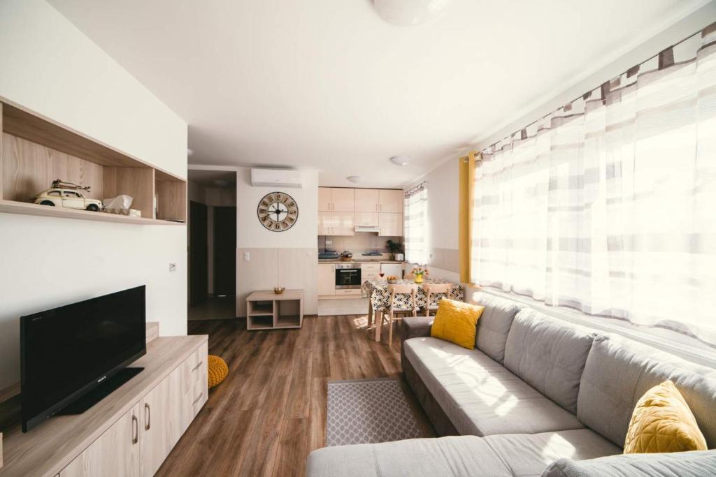a living room with a couch and a tv at D&B Lelle Apartman in Balatonlelle