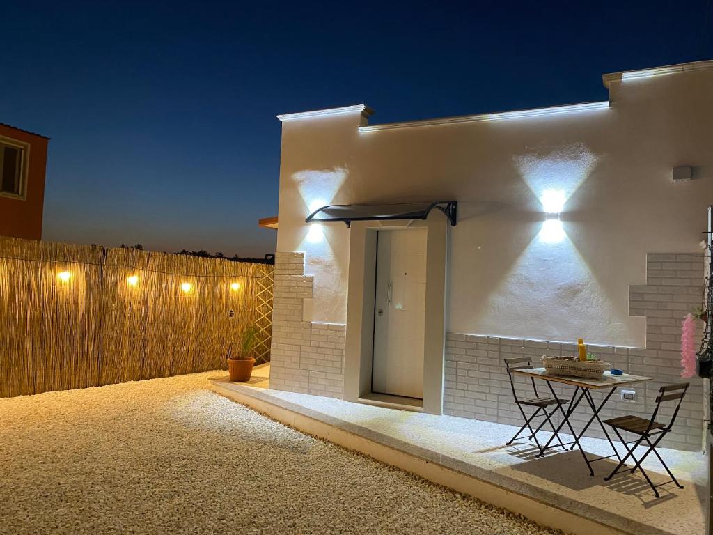 un patio con una mesa y una valla por la noche en La Dependance al Piccolo Borgo, en Crispiano