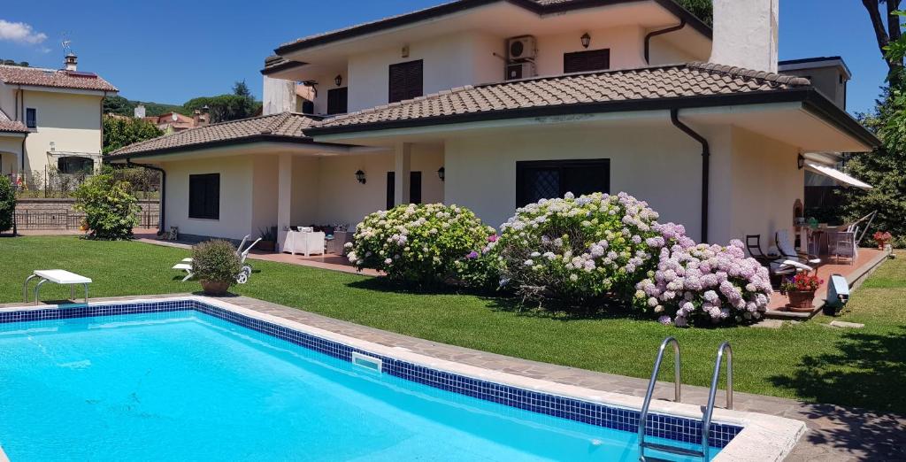 ein Haus mit einem Pool vor einem Hof in der Unterkunft La Pedica B&B in Grottaferrata