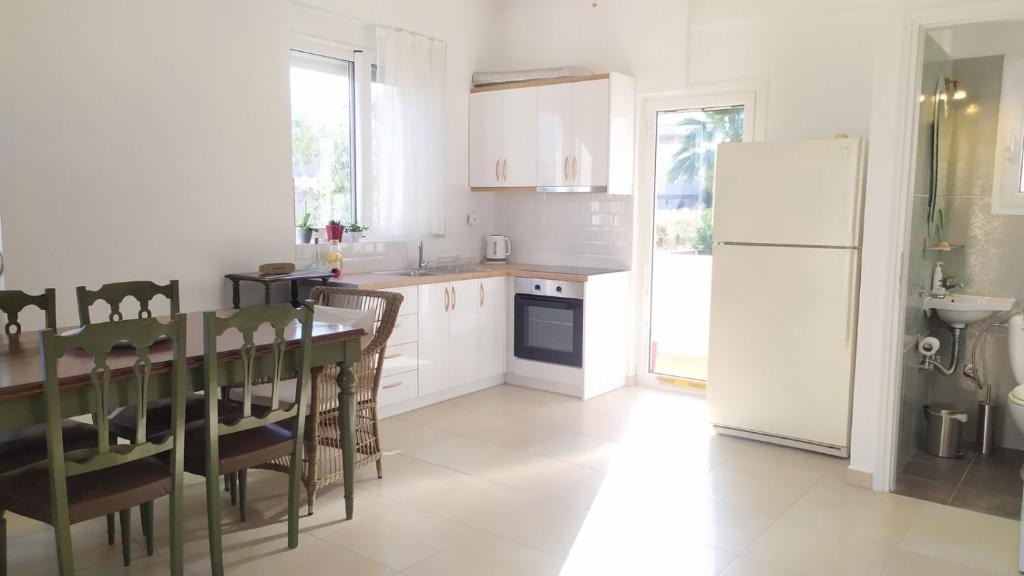 a kitchen with a table and a white refrigerator at Sunkissed and Seasalted House in Melission