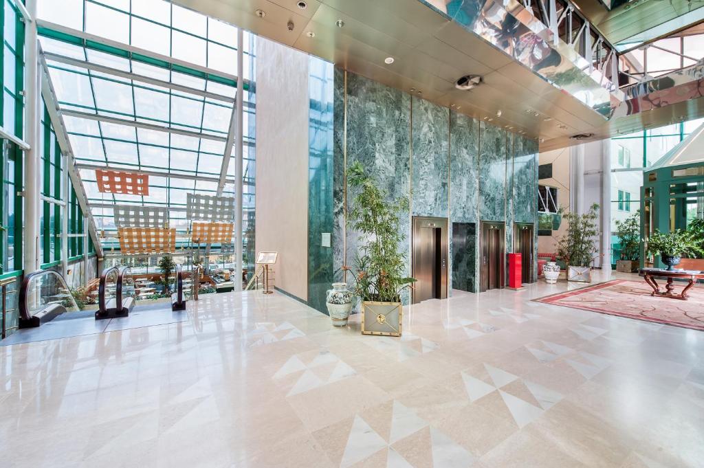 eine Lobby eines Gebäudes mit einer großen Glaswand in der Unterkunft Royal Garden in Assago