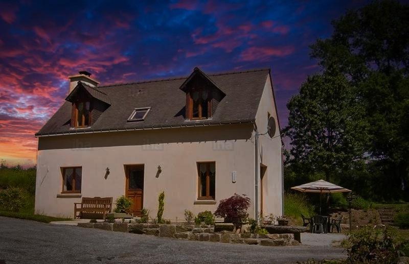 una gran casa blanca con una puesta de sol en el fondo en WILLOW en Langoëlan