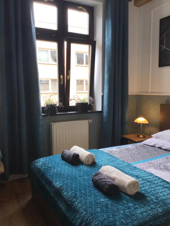 two towels on a bed in a bedroom with a window at Goldengreen Apartment in Kraków